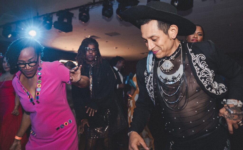 Two people lean into the party on the dance floor.